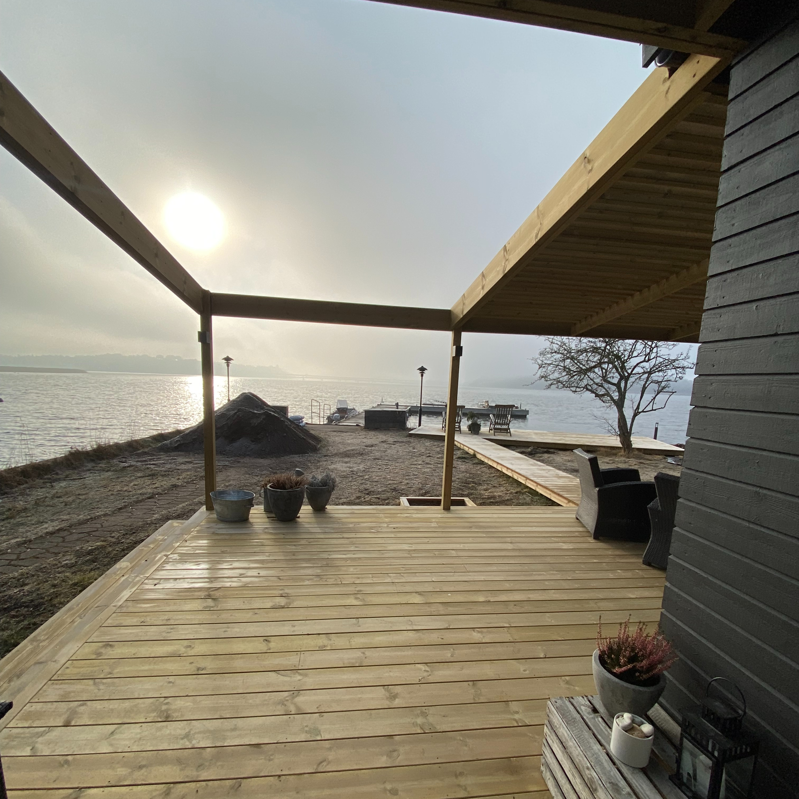 Byggnad av attefallshus och altan med brygga, morgon, utfört av Projektbygg i Österåker AB